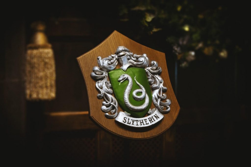El emblema de Slytherin, una de las cuatro casas de Hogwarts, con una serpiente entrelazada alrededor de una letra 'S.